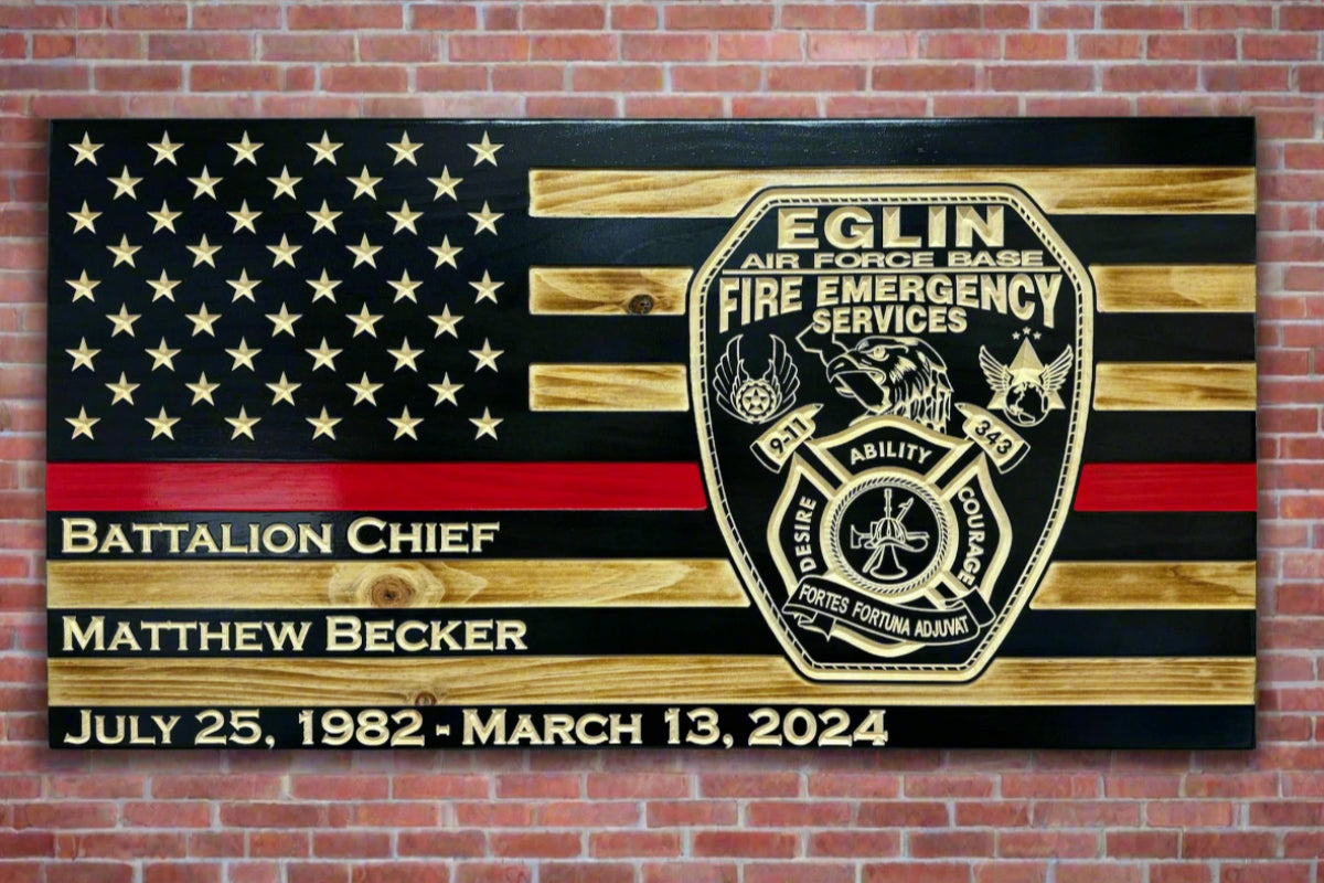 Engraved firefighter flag with Eglin Air Force Base Fire Emergency Services insignia on black-stained wood